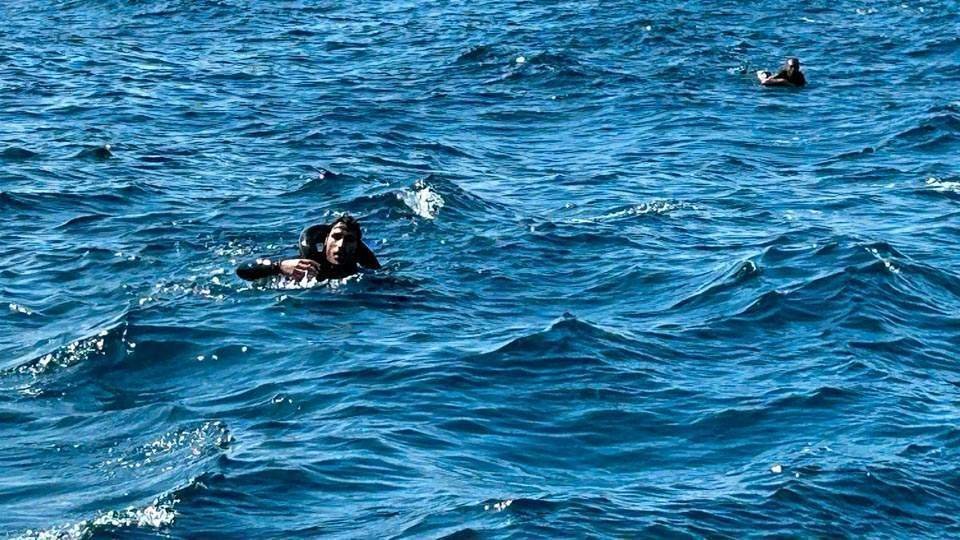 Dos migrantes tratan de mantenerse a flota mientras nadan para ganar la costa de Ceuta (C.A./ARCHIVO)